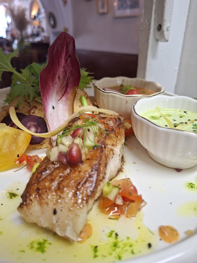 Un poisson rôti avec céréales, légumes et sauces